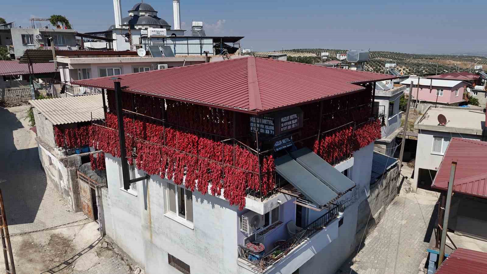 Kavurucu sıcakta tek tek ipe dizilen dolmalık acı biberler, mahalledeki balkonları kırmızıya bürüdü
